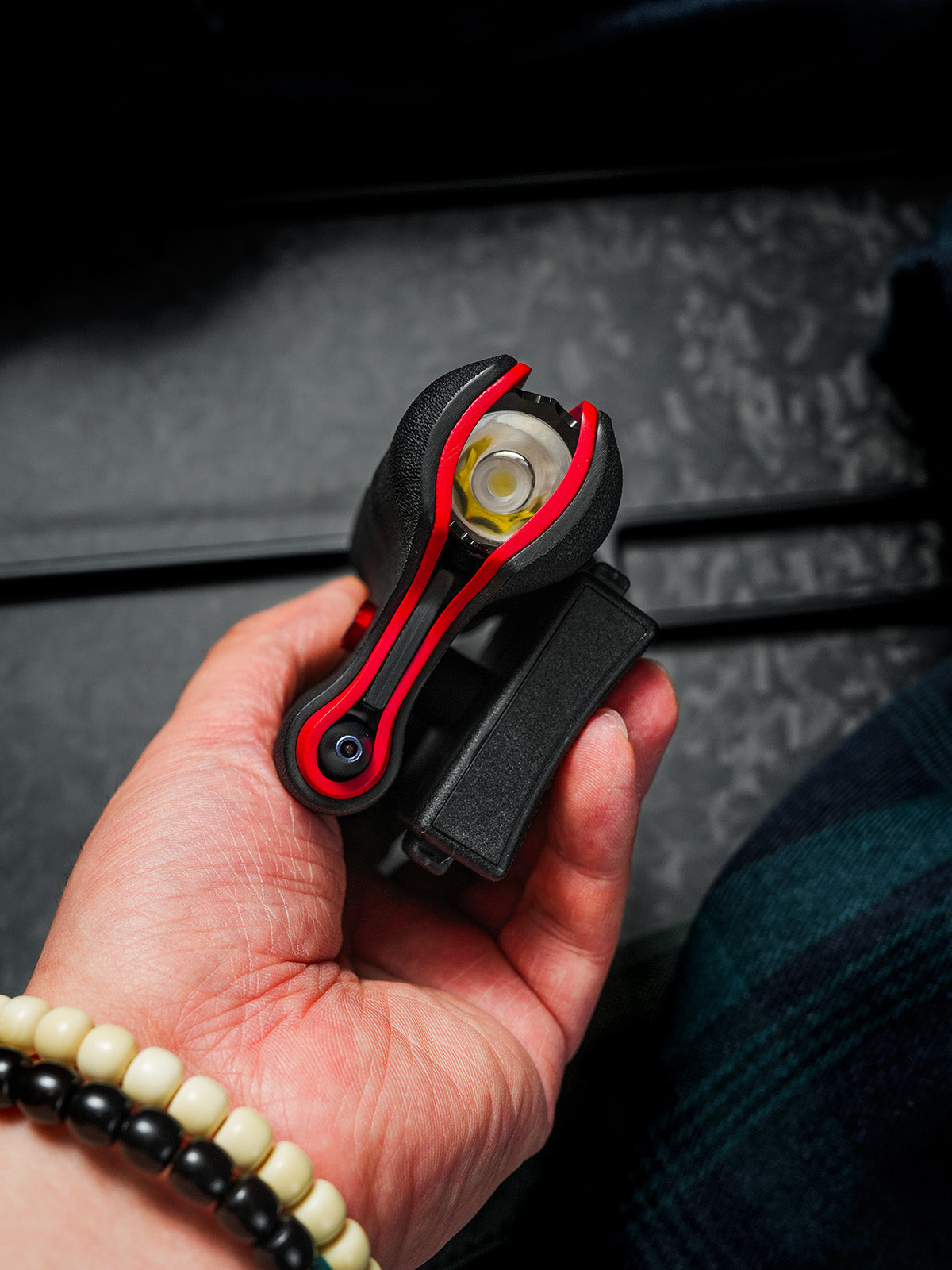 Dual-slot sheath held in hand with flashlight installed