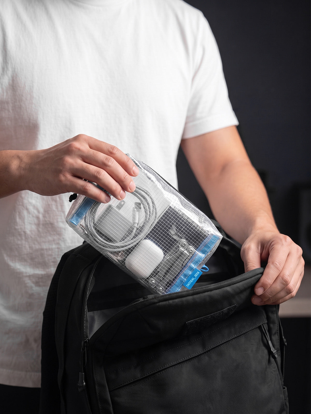 HS4 clear electronics organizer pouch being placed inside a shoulder bag