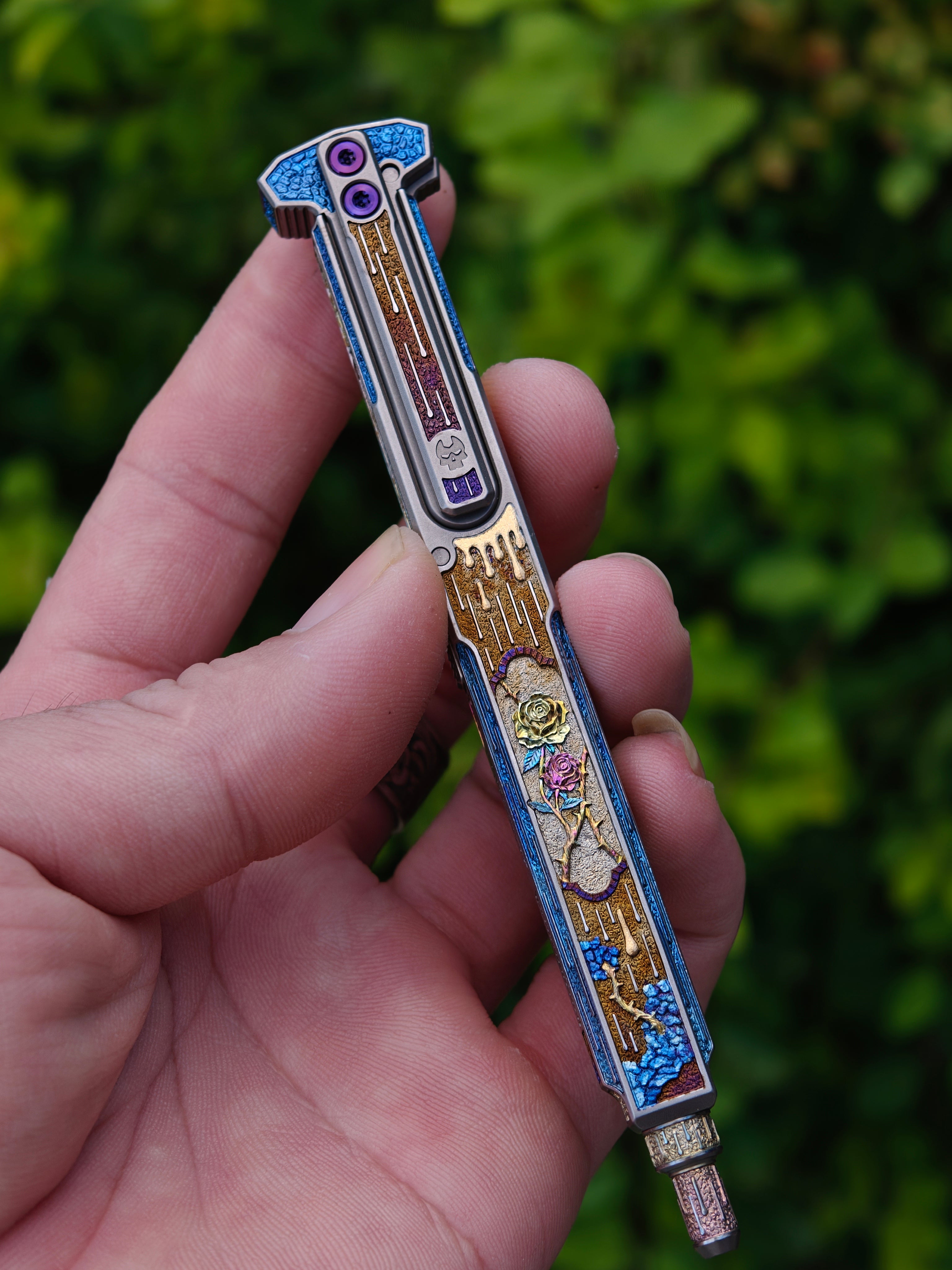 Blade of Bones engraved EDC pen held outdoors, full-length view
